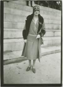 Frau in Kleid und Mantel auf dem Rennplatz in Auteuil