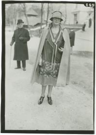 Frau in Kleid und Mantel auf dem Rennplatz in Auteuil