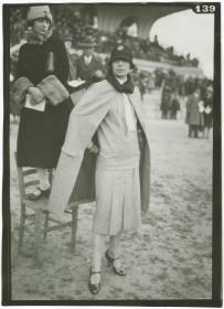 Frau in Kleid und Mantel auf dem Rennplatz in Auteuil