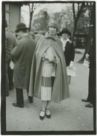 Frau in Kleid und Mantel auf dem Rennplatz in Auteuil