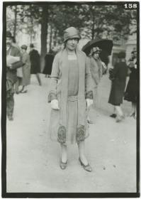 Frau in Kleid und Mantel auf dem Rennplatz in Auteuil