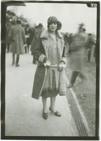Frau in Kleid und Mantel auf dem Rennplatz in Auteuil