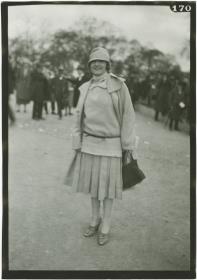 Frau in Kleid und Mantel auf dem Rennplatz in Auteuil