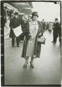 Frau in Kleid und Mantel auf dem Rennplatz in Auteuil