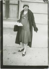Frau in Kleid und Mantel auf dem Rennplatz in Auteuil