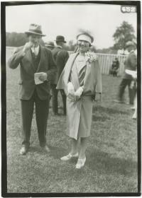 Frau in Mantel und Mann in Anzug auf dem Rennplatz in Chantilly