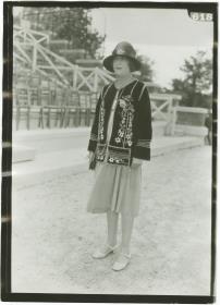 Frau in Kleid und Jacke auf dem Rennplatz in Deauville