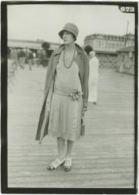 Frau in Kleid und Mantel auf dem Rennplatz in Deauville