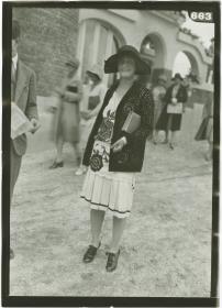 Frau in Kleid und Jacke auf dem Rennplatz in Deauville