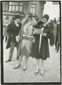 Frauen in Kleidern und Mänteln auf dem Rennplatz in Longchamp