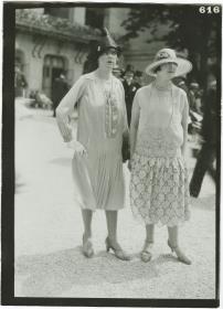 Frau in Kleid und Frau in Ensemble auf dem Rennplatz in Longchamp