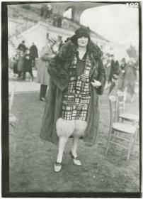 Frau in Kleid und Mantel auf dem Rennplatz in Auteuil