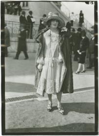 Frau in Kleid und Mantel auf dem Rennplatz in Auteuil