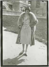 Frau in Kleid und Mantel auf dem Rennplatz in Auteuil