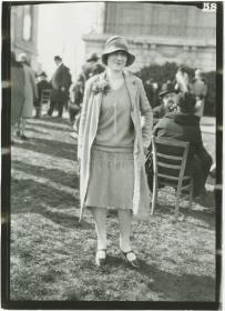 Frau in Kleid und Mantel auf dem Rennplatz in Auteuil