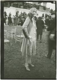 Frau in Kleid und Mantel auf dem Rennplatz in Auteuil