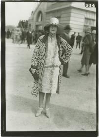 Frau in Kleid und Mantel auf dem Rennplatz in Auteuil