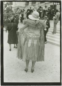 Frau in Kleid und Mantel auf dem Rennplatz in Auteuil