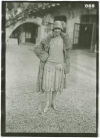 Frau in Kleid und Mantel auf dem Rennplatz in Longchamp