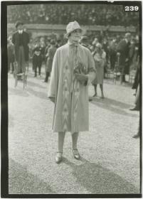 Frau in Mantel auf dem Rennplatz in Longchamp