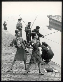 Gloria Friedrich in orangefarbenem Wollkostüm und Bettina Lauer in Kostüm aus blau-weiß-karierter Wolle mit ledernem Taillengürtel von Pierre Cardin am Ufer der Seine